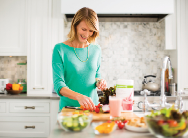 Woman Making A Shake With Herbalife Nutrition Products And Fruit On The Table