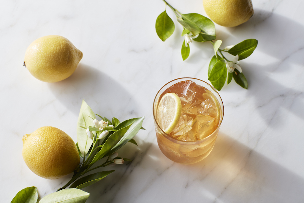 Herbal Aloe Mango Concentrate Drink with orange twist drink Herbal Beverage for hydration glass with natural flowers